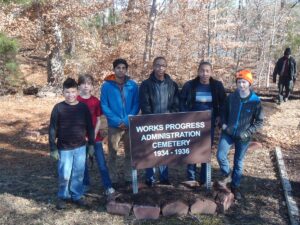 five young men standing behind the WPA Cemetary sign